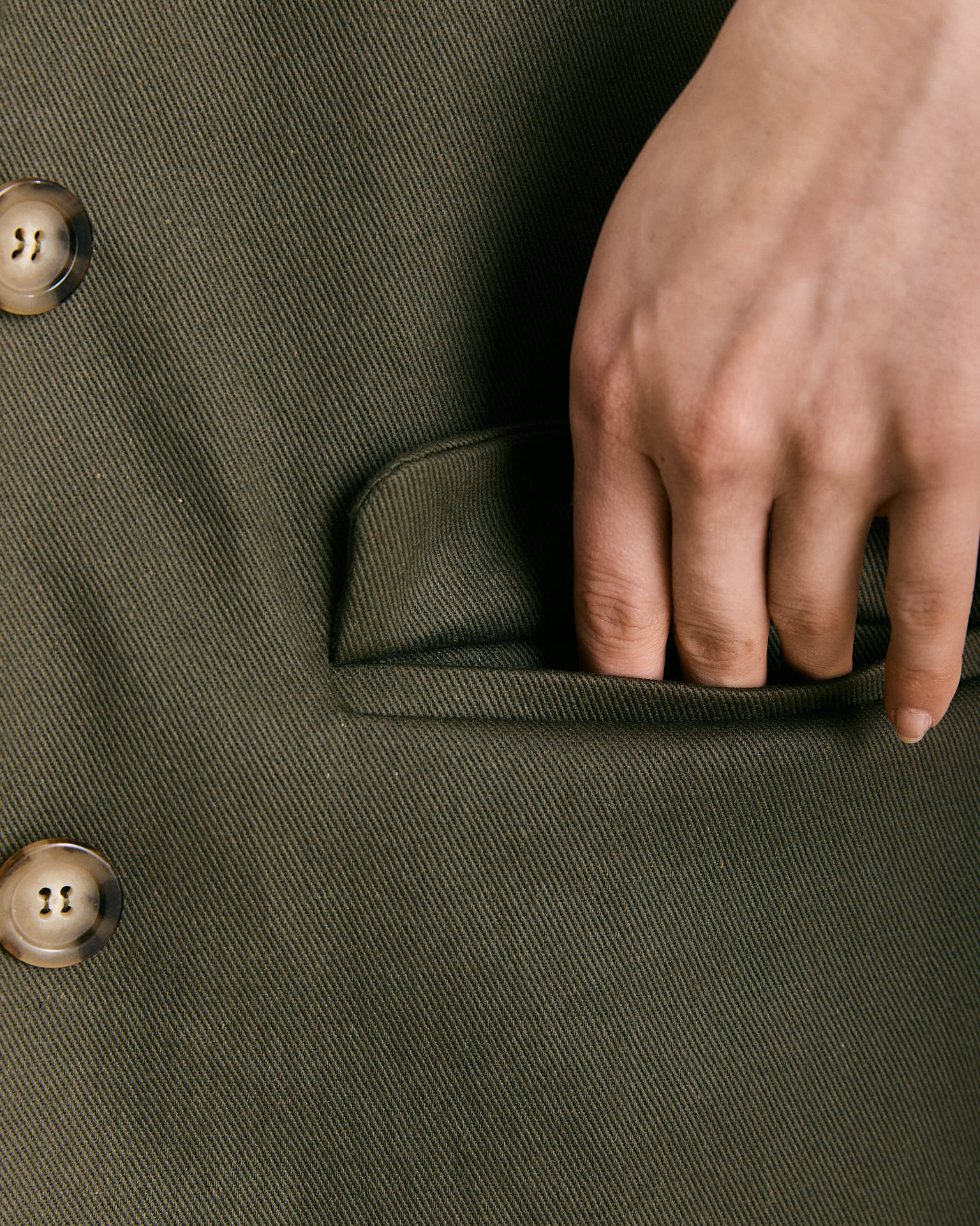Un blazer realizzato in 100% cotone color verde sottobosco.  Il blazer Mimi rispetta la linea asciutta e maschile del capo, una giacca leggermente sfiancata con due tasche con pattina e due bottoni sul davanti.